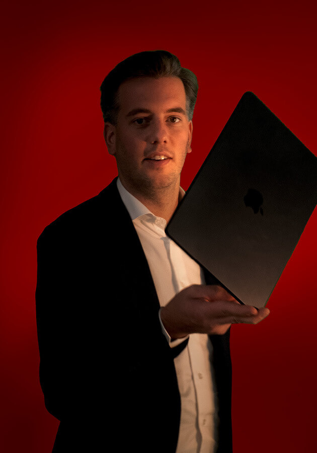 Cedric Scherpenberg die een laptop balanceert op zijn vingers